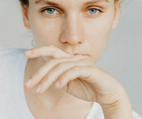 Close-up of a person's serene face with eyes closed, focusing on breath.
